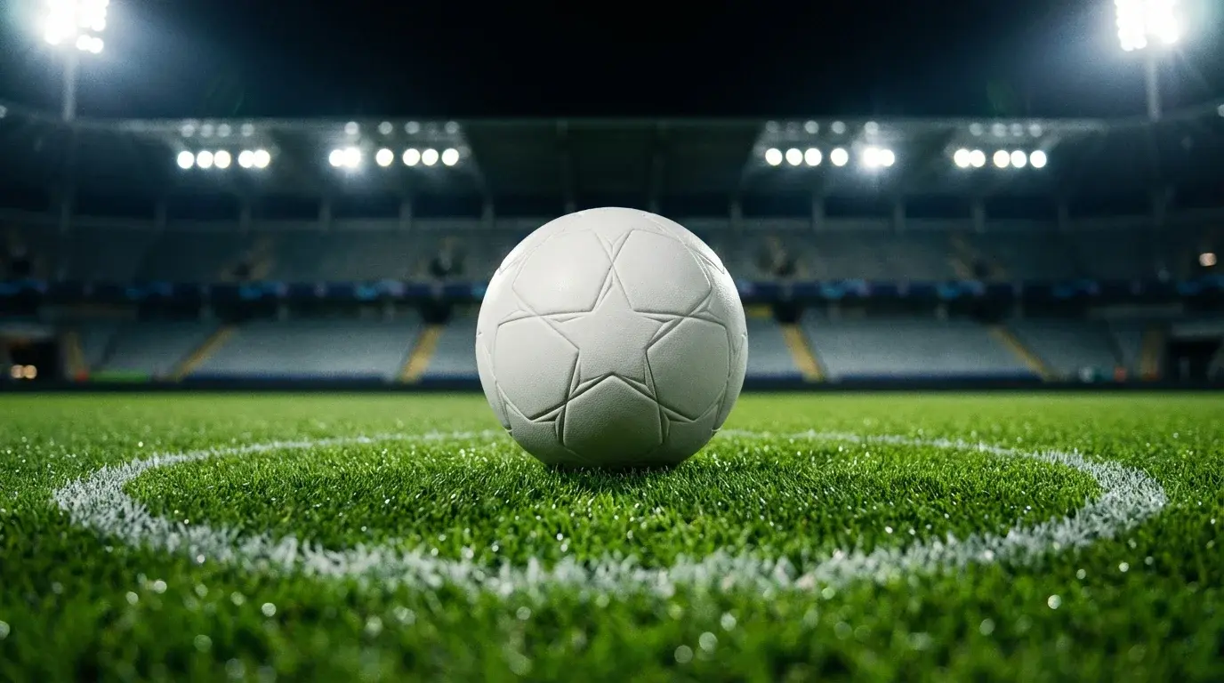 Bola de futebol da Champions League no centro de um relvado de estádio europeu iluminado