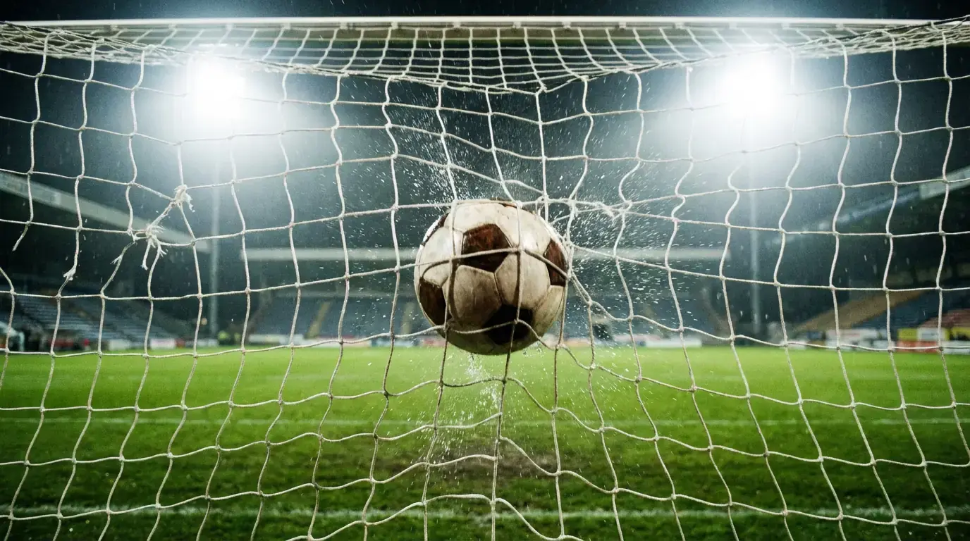 Rede de baliza de futebol vista de perto com bola a entrar na baliza
